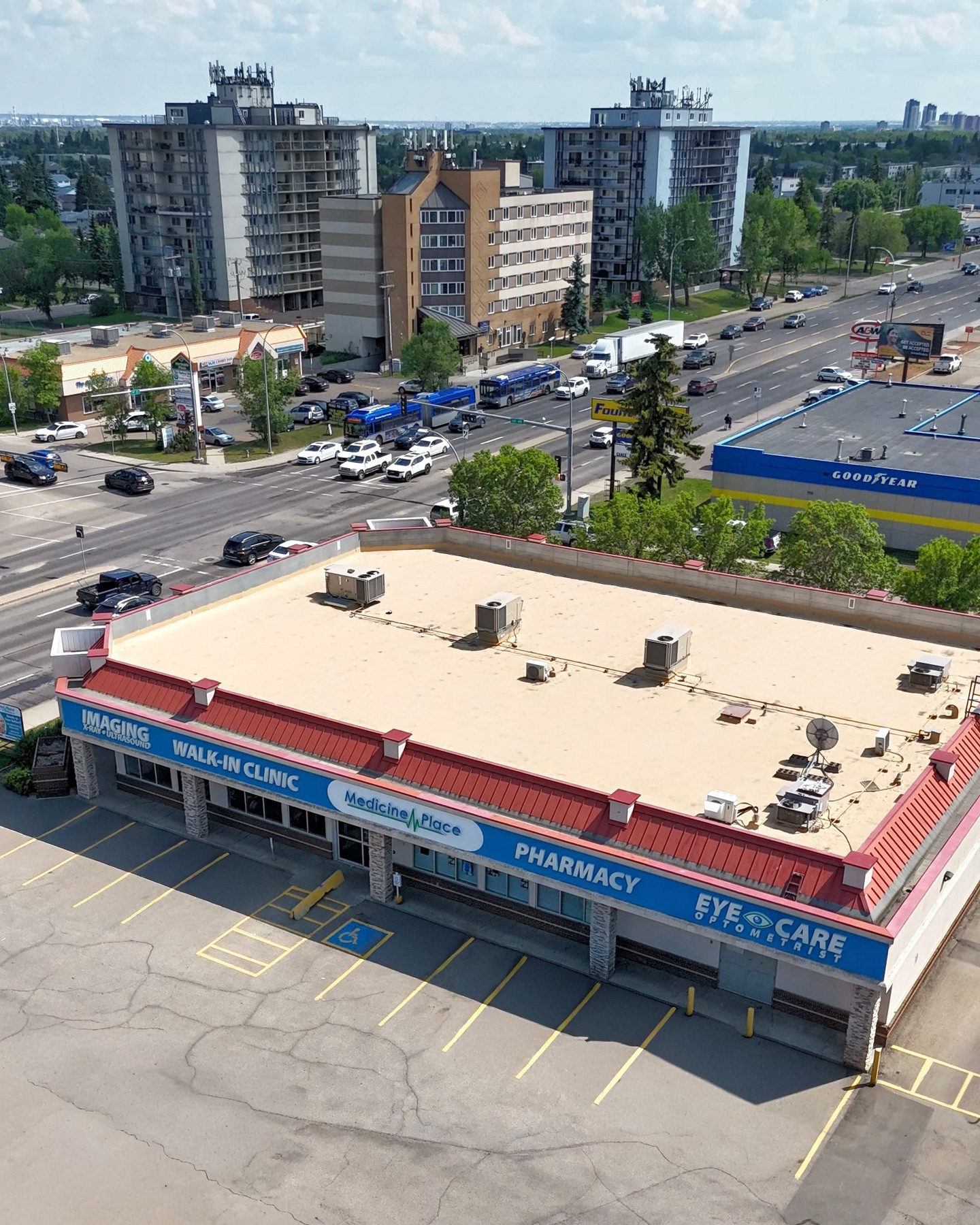Aerial view of a Medicine Place building with walk-in clinic, pharmacy, imaging and eye care signage.