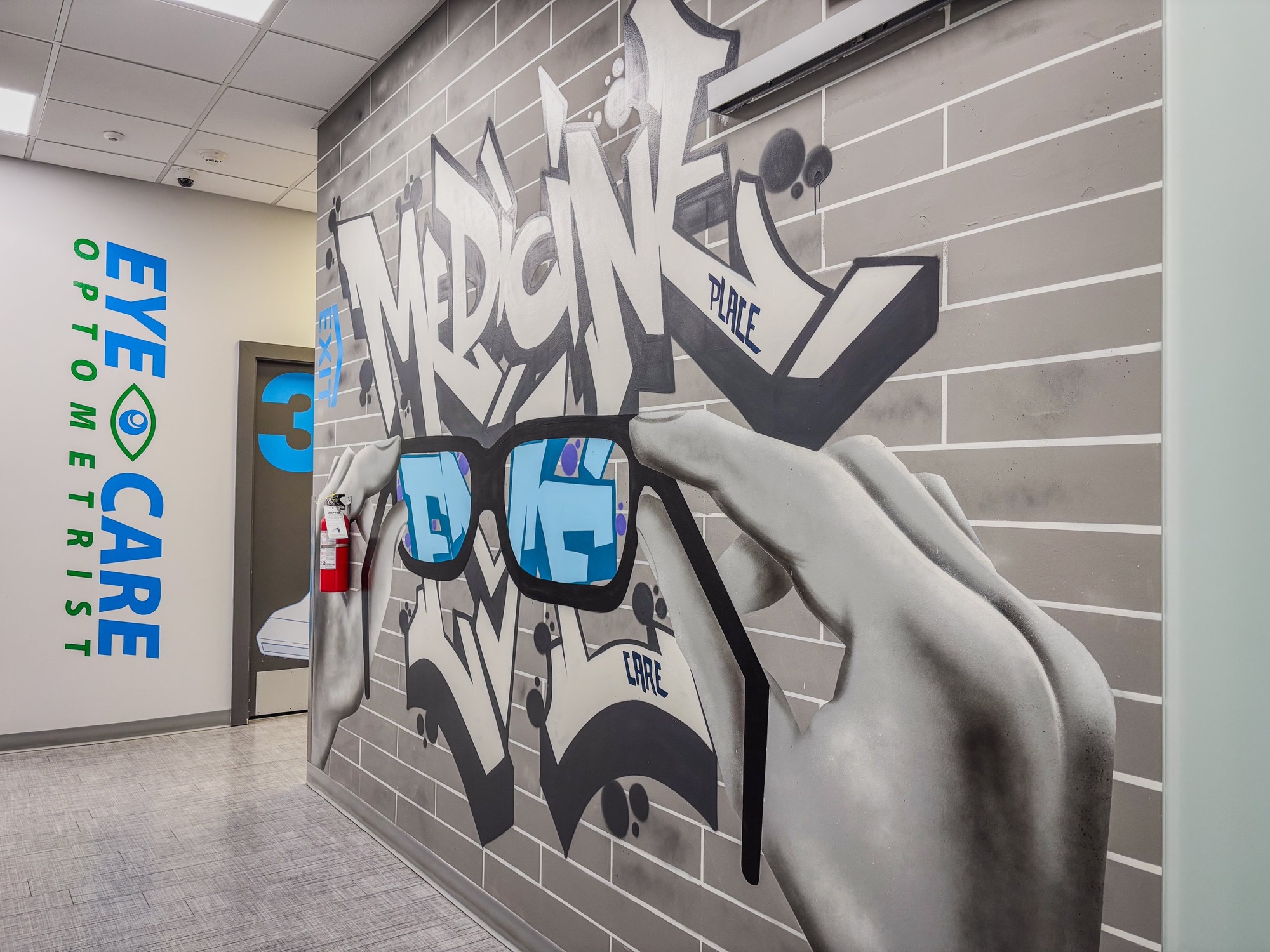 The Eye Care optometrist entrance beside a street-art mural of hands holding glasses.